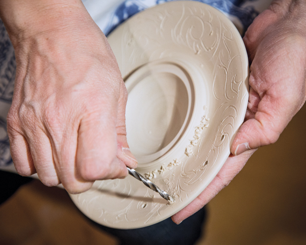 6 I drill into the clay by hand with drill bits of various sizes to create circles of consistent diameter.