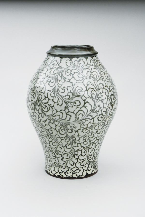 9 Tall vase, white stoneware, karakusa mon (Japanese arabesque) carved freehand through iron slip, opaque glaze.