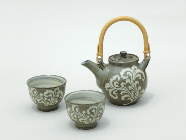 6 Tea set (normally includes six cups), iron-rich clay, carved free hand, inlaid white slip, cup interiors have hakeme brushed slip, clear glaze.