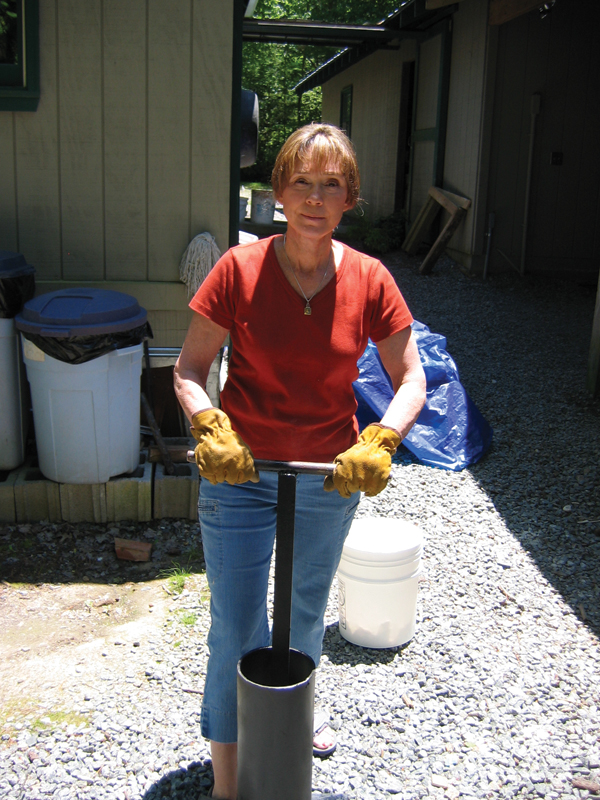 Judith Duff with her homemade stamp mill used for crushing feldspar to make shino glazes, 2005.