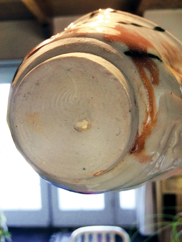 The foot on Betty Woodman’s thrown cup showing the celadon glaze-filled air bubble.